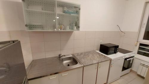 una cucina con lavello e microonde di Spacious Condo In Luxury Complex Belville, Belgrade a Novi Beograd