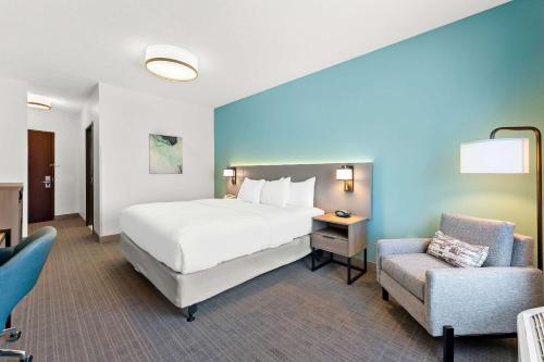 TunkhannockにあるComfort Inn & Suitesのベッドと椅子付きのホテルルーム
