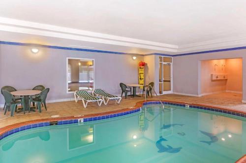 a pool with chairs and tables in a hotel room at Comfort Inn & Suites Chesapeake - Portsmouth in Chesapeake