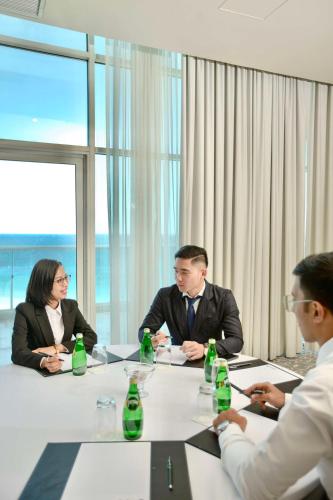 a group of people sitting around a table in a meeting at Radisson Blu Resort, Fujairah in Dibba