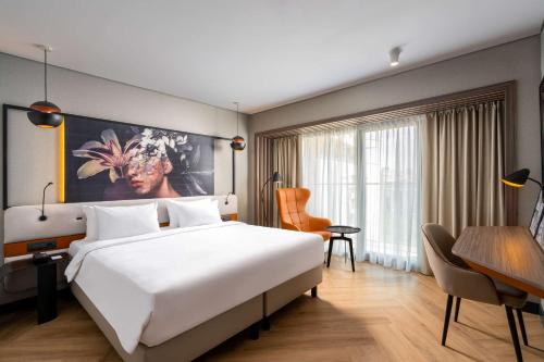 ブカレストにあるラディソン ブルー ホテル ブカレストの大きなベッドとデスクが備わるホテルルームです。