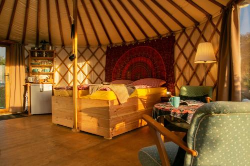 ein Schlafzimmer in einer Jurte mit einem Bett und einem Tisch in der Unterkunft Halbinsel Resort Peenemünde in Peenemünde
