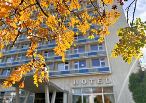 um hotel com folhas amarelas em frente a um edifício em Hotel Magnólia em Piešťany