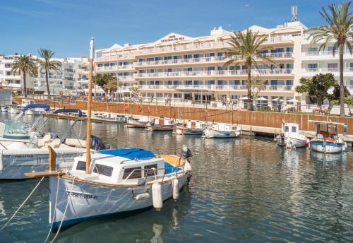 um grupo de barcos ancorados numa marina com um hotel em Catalonia del Mar - Adults Only em Cala Bona
