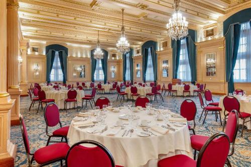 a banquet hall with tables and chairs and chandeliers at The Fort Garry Hotel Spa and Conference Centre, Ascend Hotel Collection in Winnipeg