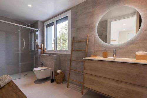 ein Badezimmer mit einem Waschbecken, einem WC und einem Spiegel in der Unterkunft Naramia Sagaro Villa with Poolgarden10 Pax in S'Agaró
