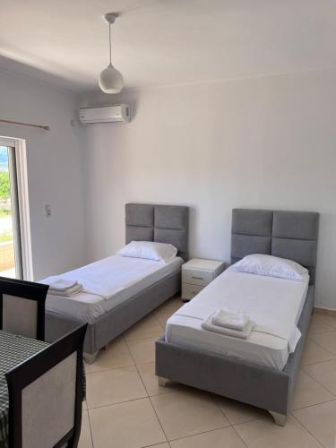 due letti in una stanza con finestra di Vila Flavin 1 a Ksamil