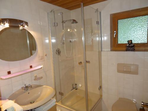 La salle de bains est pourvue d'une douche en verre et d'un lavabo. dans l'établissement Haus Buchenwald, à Ramsau bei Berchtesgaden