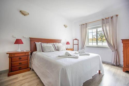 biała sypialnia z dużym łóżkiem i 2 ręcznikami w obiekcie Apartamento ROSA Beach Old Town w Albufeirze