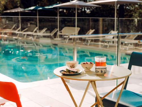 una bandeja de comida en una mesa junto a una piscina en greet Hotel La Rochelle Centre, en La Rochelle