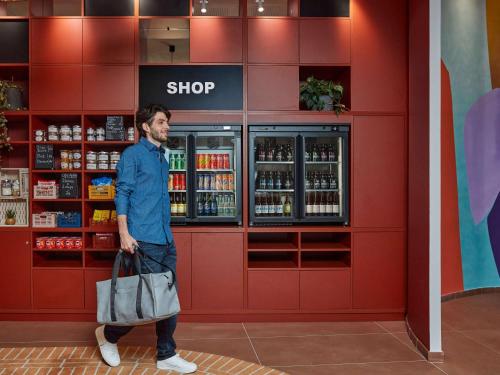 a man walking in front of a shop at Aparthotel Adagio Original Toulouse Centre La Grave in Toulouse