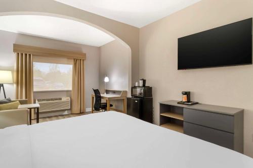 a hotel room with a bed and a flat screen tv at Comfort Suites Shenandoah-The Woodlands in The Woodlands