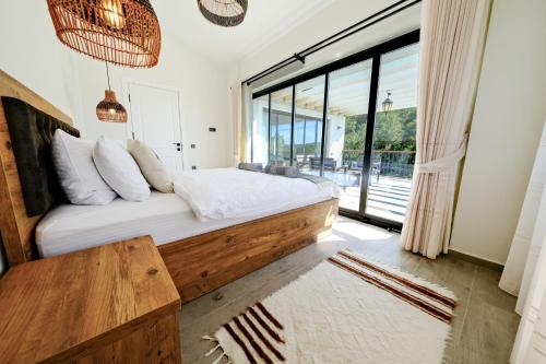 une chambre avec un lit et une grande fenêtre dans l'établissement Oleander Hills Villa - Family-Friendly Luxury Villa Yesiluzumlu Fethiye by Sunworld Villas, à Fethiye