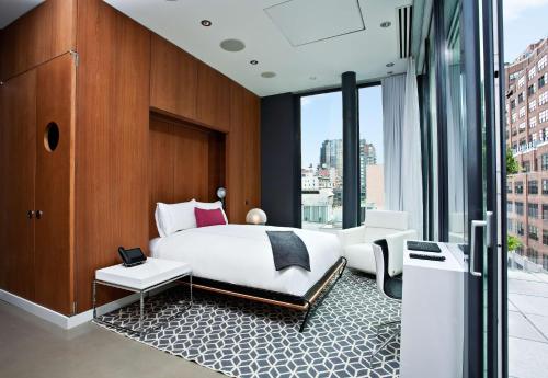 ein Schlafzimmer mit einem Bett und einem großen Fenster in der Unterkunft Dream Downtown, by Hyatt in New York