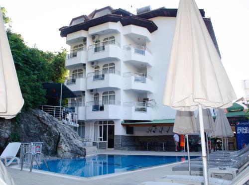 a hotel with a pool and two umbrellas at Dilhan Hotel in Marmaris