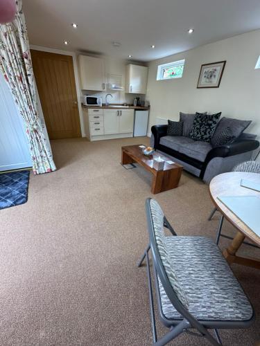 a living room with a couch and a table at Rose Cottage at Orchard House in Rampton