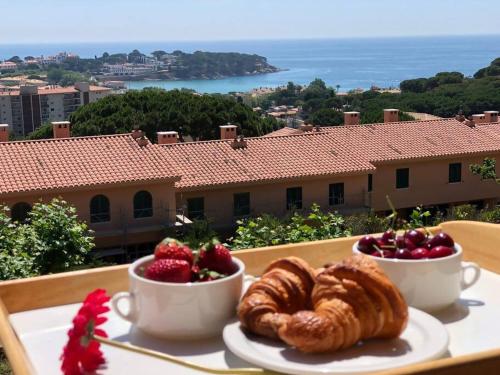 a table with two cups of coffee and a plate of food at Sagaró sea housegardenbarbacue8 paxsea view in Sant Feliu de Guixols