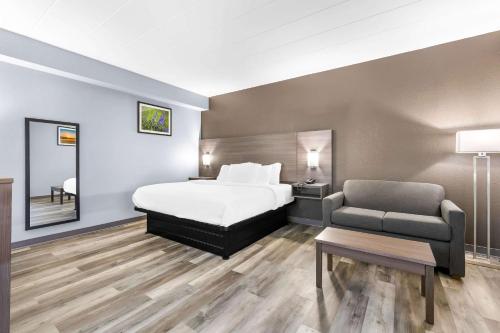 um quarto de hotel com uma cama e uma cadeira em Quality Inn em Lawrenceburg