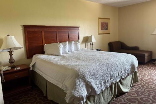 Quality Inn - Norman near University في نورمان: غرفة فندقية بسرير كبير وكرسي