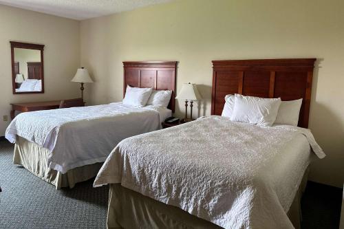 una camera d'albergo con due letti con lenzuola bianche di Quality Inn - Norman near University a Norman
