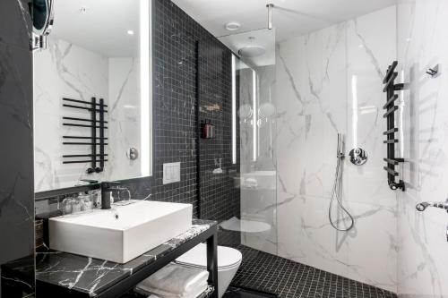 a black and white bathroom with a sink and a shower at Hótel Reykjavík Saga in Reykjavík