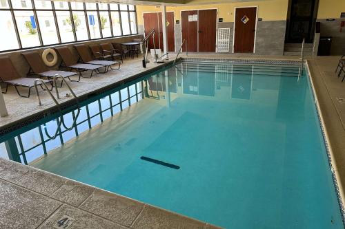 - une grande piscine avec des chaises dans un bâtiment dans l'établissement Quality Inn - Norman near University, à Norman