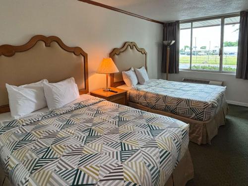 a hotel room with two beds and a window at Motel 6 Pocomoke City, MD in Pocomoke City