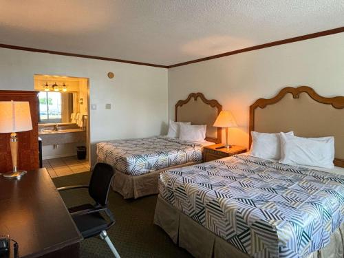 a hotel room with two beds and a desk at Motel 6 Pocomoke City, MD in Pocomoke City