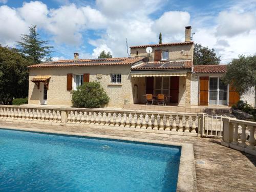 une maison avec une piscine devant une maison dans l'établissement La maison des oliviers, à Beaumes-de-Venise