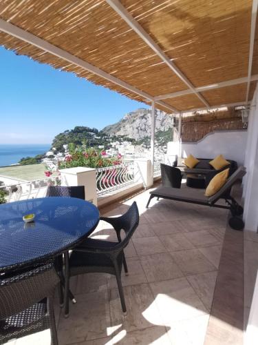 a patio with a table and chairs and the ocean at Villa La Panoramica Sea View in Capri