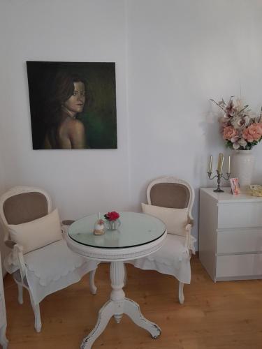 einen Tisch und zwei Stühle in einem Zimmer mit einem Gemälde in der Unterkunft Espaco Edla in Sintra
