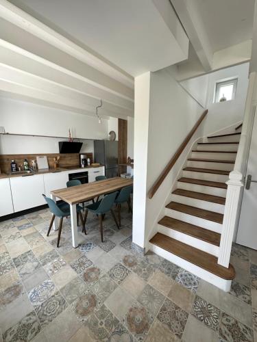 - une cuisine et une salle à manger avec une table et des escaliers dans l'établissement Maison entre Aven et Belon - Riec sur Belon, à Riec-sur-Bélon
