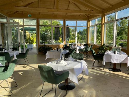 a restaurant with tables and chairs and windows at Gartenhotel & Weingut Pfeffel Dürnstein in Dürnstein