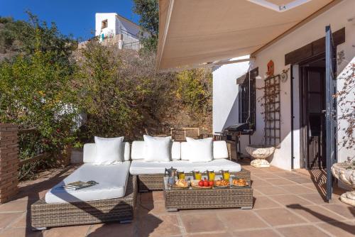 a patio with two white couches and a tray of food at Málaga sea views country house in Málaga