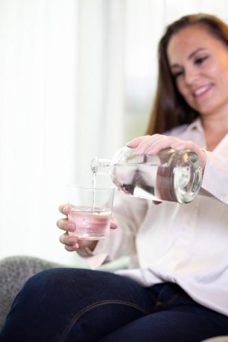 a woman sitting on a couch holding a glass of wine at b-smart hotel Widnau in Widnau