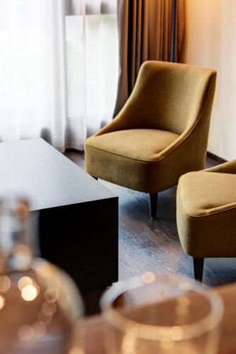 a living room with two chairs and a table and a television at b-smart hotel Widnau in Widnau