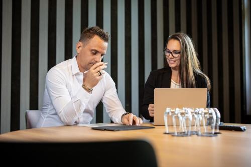 a man and woman sitting at a table with a laptop at b-smart hotel Widnau in Widnau