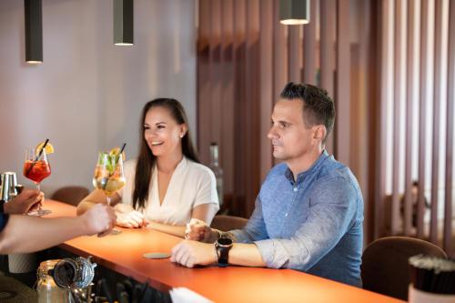 a man and woman sitting at a table with drinks at b-smart hotel Widnau in Widnau