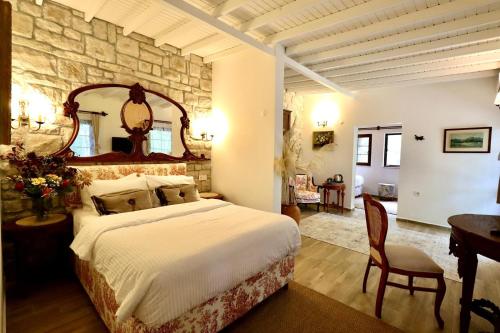 a bedroom with a large bed and a stone wall at Kemerbag 29 Guest House 12 Yaş Üstü in Bozcaada