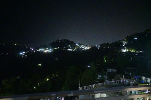 a city at night with lights on a mountain at Saadhan Homestay in Mussoorie