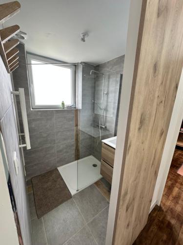 La salle de bains est pourvue d'une douche et d'une cabine de douche en verre. dans l'établissement Maison entre Aven et Belon - Riec sur Belon, à Riec-sur-Bélon