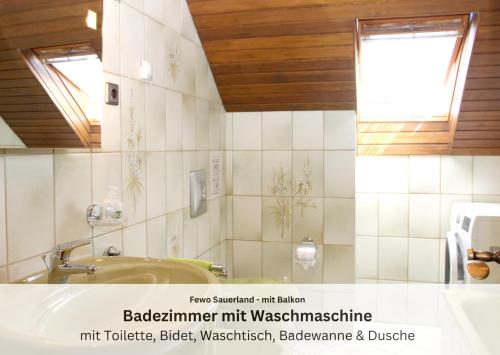 a bathroom with a sink and a tub and a mirror at Ferienwohnungen Sauerland und Olsberg in Olsberg