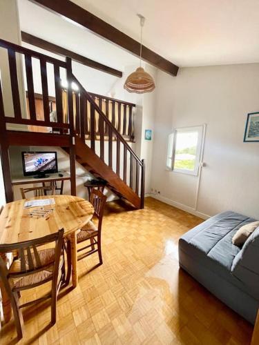 un salon avec une table et un canapé dans l'établissement Appartement à 400m de la plage avec parking - CAPBRETON, à Capbreton