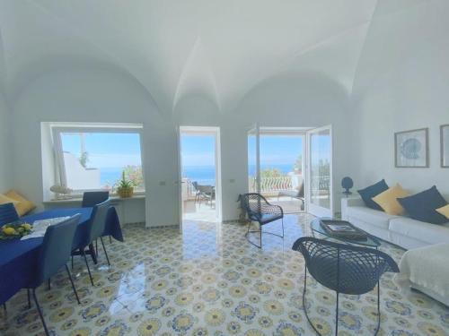 een woonkamer met een bank en een tafel en stoelen bij Villa La Panoramica 3 camere 3 bagni in Capri