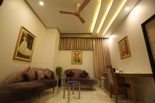 a living room with a couch and a ceiling fan at Neonz Resort & Club in Anand