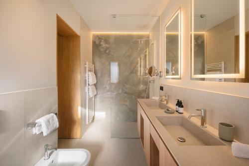 a white bathroom with two sinks and a shower at ANTON Nature Hideaway in Natz-Schabs