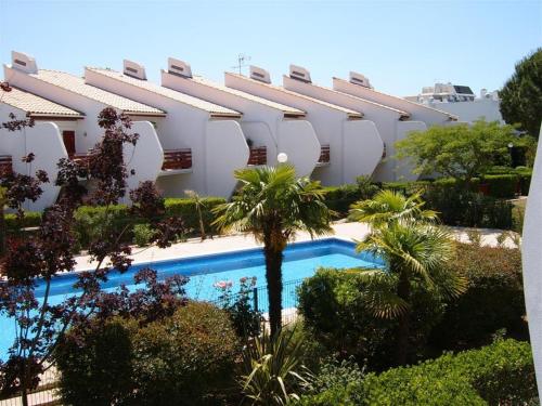 un immeuble avec une piscine devant un immeuble dans l'établissement Résidence Green Village, à La Grande Motte