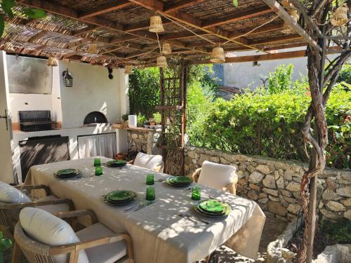 une table et des chaises sous une pergola dans l'établissement La Belle Histoire, à Claviers