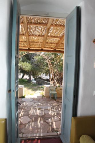 an open door to a patio with a chair outside at ΞΕΝΩΝΑΣ ΜΑΡΗ in Chrousa
