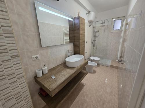 a bathroom with a sink and a toilet and a mirror at Sea and Sand's Ville HOWME in Bari